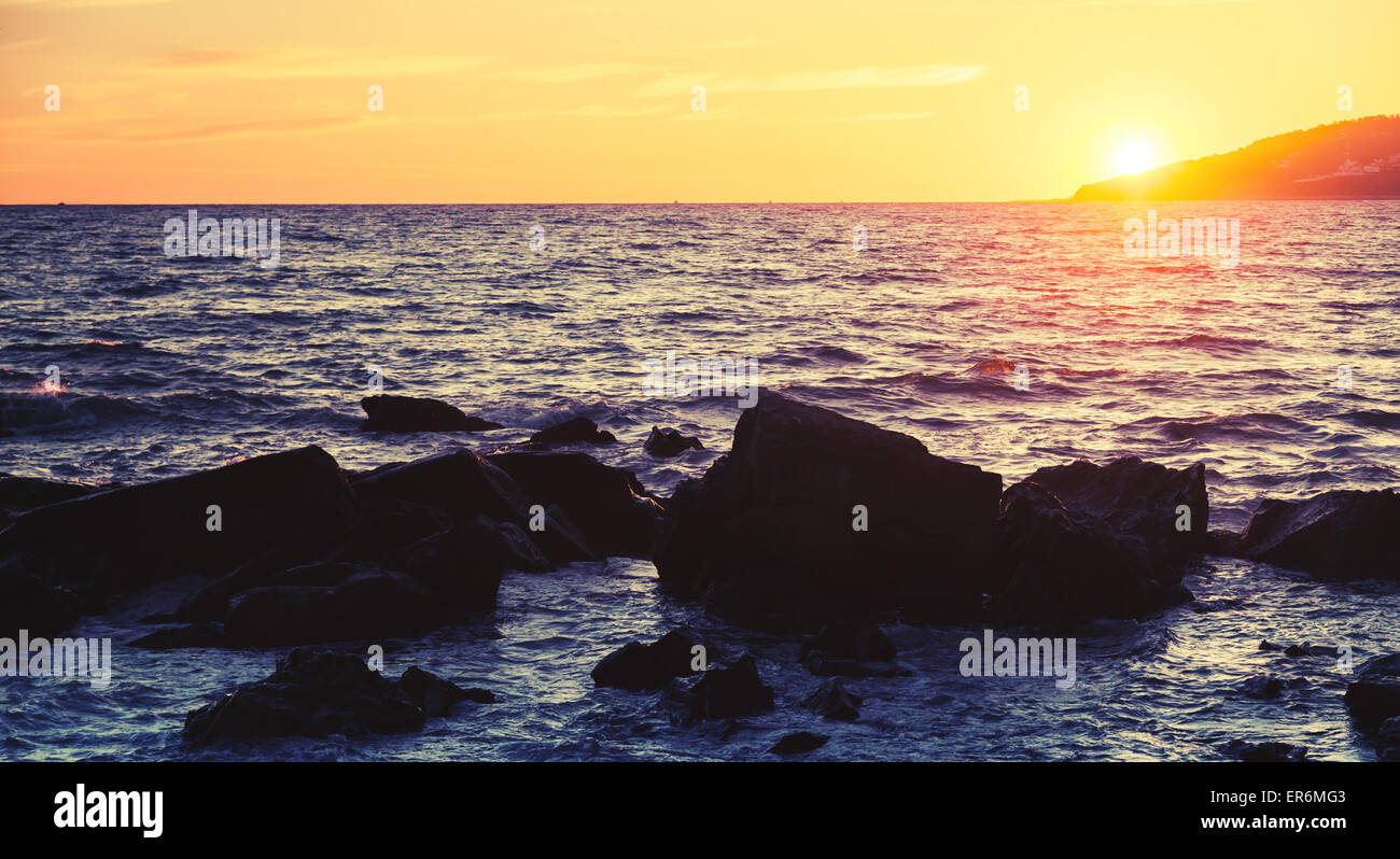 Des pierres et de l'eau côtière, coucher de soleil sur la côte de l'océan Atlantique au Maroc, Tanger. Filtre photo correction tonale Vintage Banque D'Images