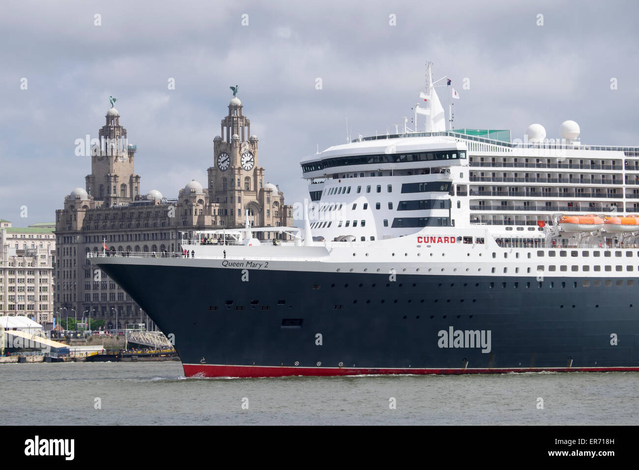 Le Queen Mary 2 traversant la rivière Mersey en face de l'immeuble du foie, Liverpool, Merseyside Banque D'Images