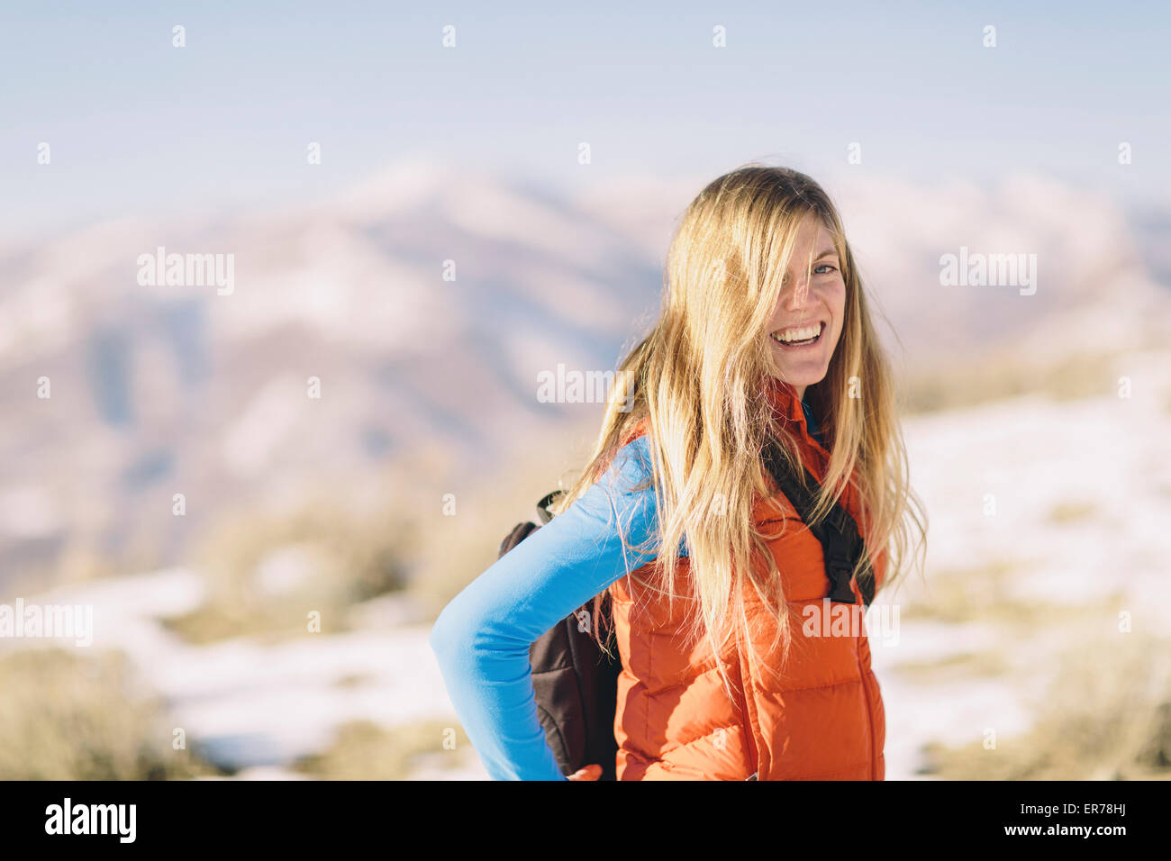 Une jeune femme aux cheveux blonds sourires sur une randonnée en hiver. Banque D'Images
