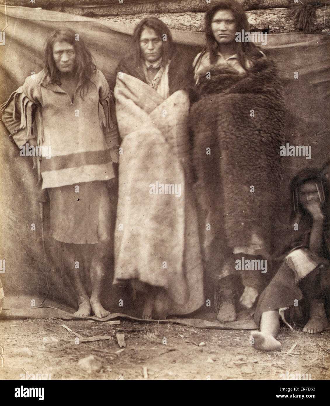 Groupe d'Amérindiens, trois debout, un assis sur le Banque D'Images