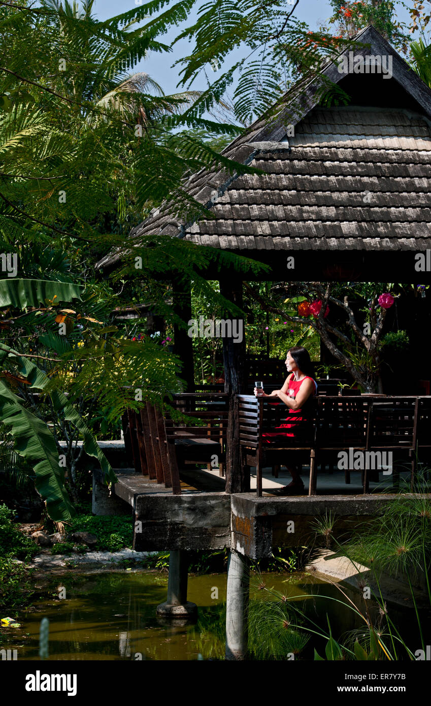 Femme en robe rouge à traditionnel Thai House Banque D'Images