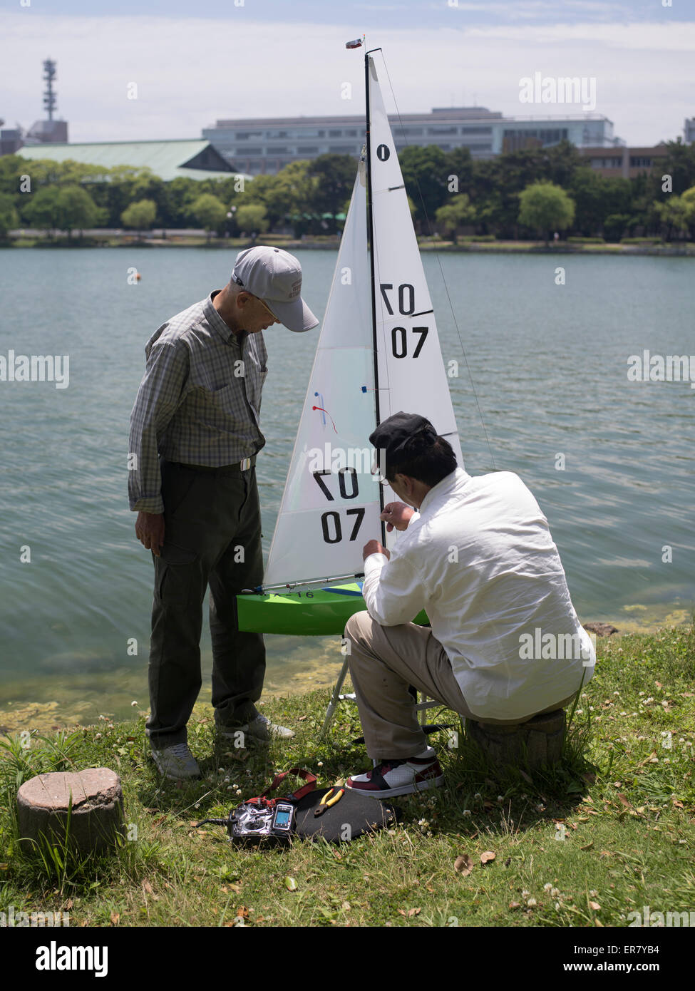 Les retraités japonais relaxant avec un modèle bateau au Parc Ohori Koen ( ) La ville de Fukuoka, Kyushu, Japon Banque D'Images