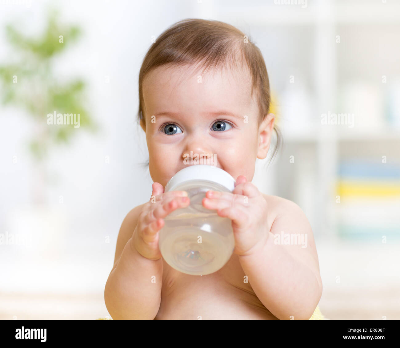 Sweet baby girl holding bouteille et l'eau potable Banque D'Images