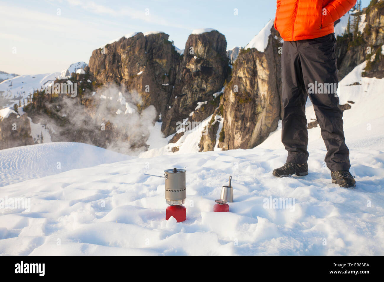 Un grimpeur s'occupe de son réchaud de camping en camping dans les montagnes. Banque D'Images