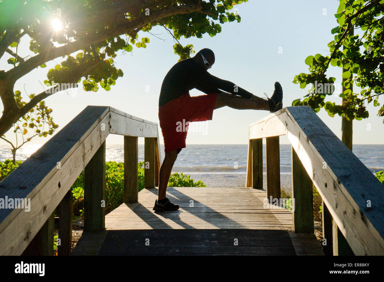 L'homme s'étend sur une plage boardwalk Banque D'Images