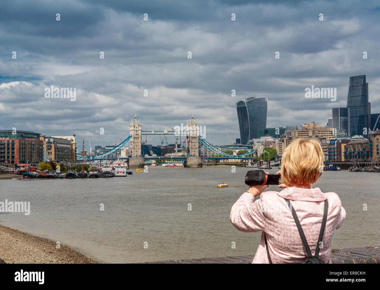 Un touriste de prendre une photo de la Tamise à l'Ouest en direction de Tower Bridge et de la construction de talkie walkie, Londres, UK Banque D'Images