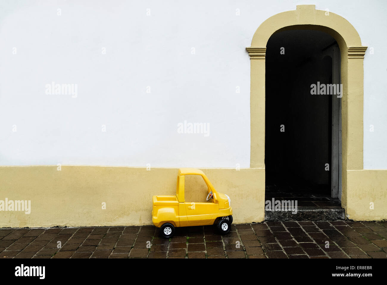 Petite voiture jaune par chambre Banque D'Images