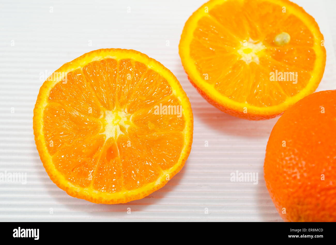 Les oranges juteuses de moitié sur un morceau de carton blanc Banque D'Images