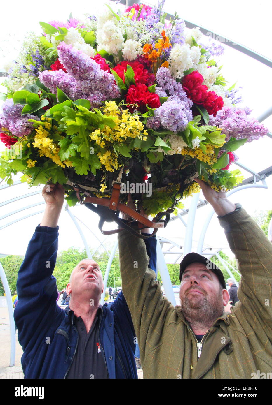 Garland décideurs de mettre la touche finale à une coiffe de fleurs faites en célébration de la journée Apple chêne,Castleton, Derbyshire, Royaume-Uni Banque D'Images