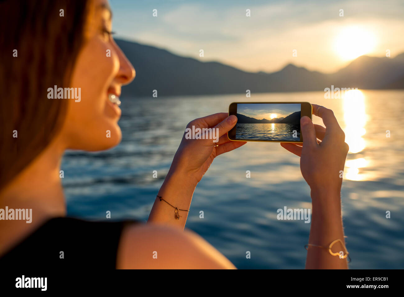 Femme photographier le coucher du soleil Banque D'Images