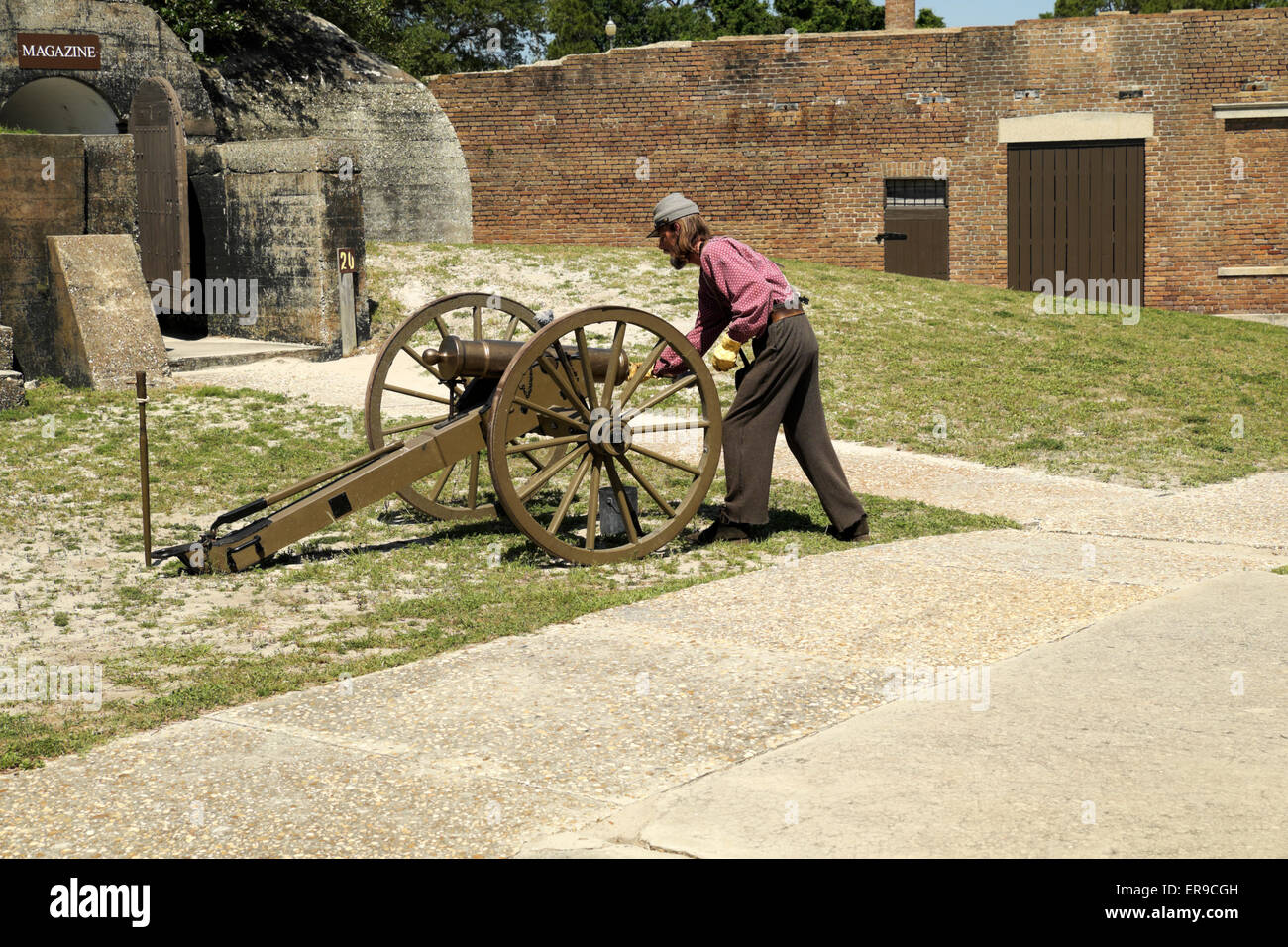 L'homme en habit de guerre civile démontre le chargement et tir d'un canon d'époque à Fort Gaines. Banque D'Images