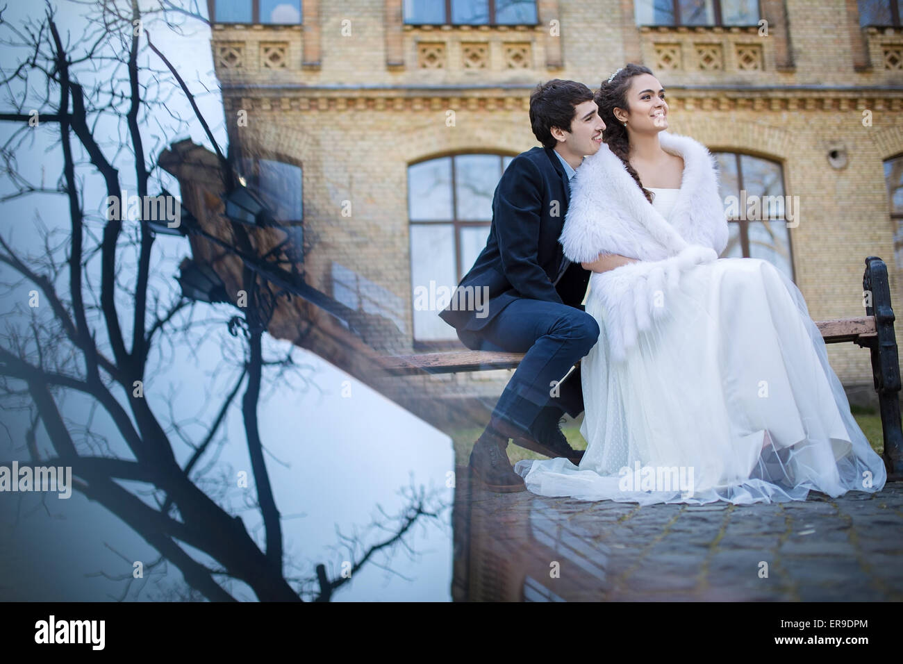 Wedding couple assis sur un banc de parc Banque D'Images