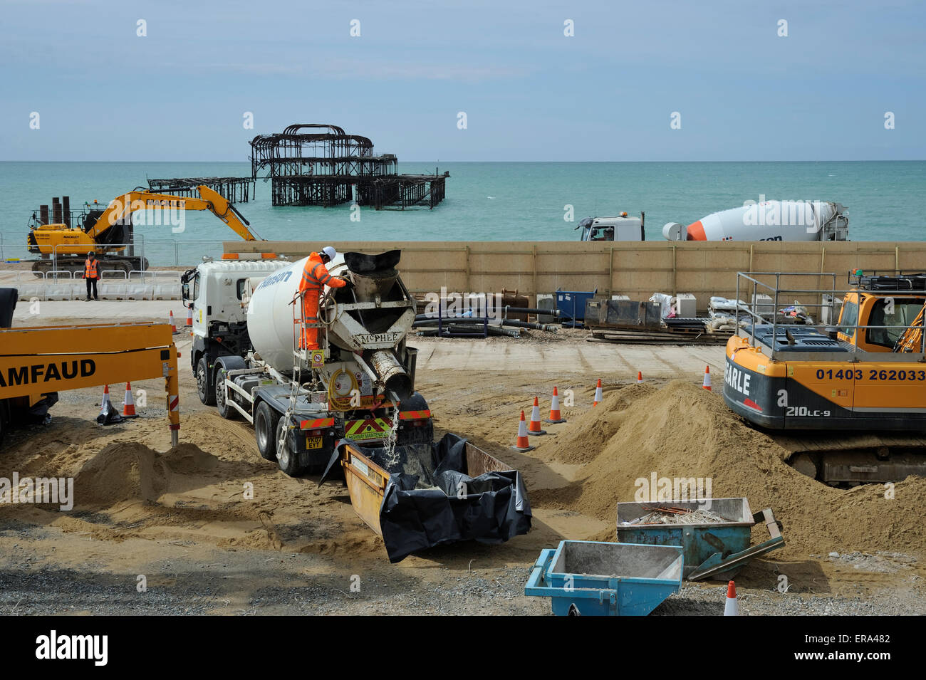 Sur le site de construction du Brighton BA J360, un homme nettoie une bétonnière camion avant qu'il ne quitte le site de recueillir un autre chargement. Le béton sera le sous-sol et des fondations pour l'i360's tower. Au cours du processus autour de 2 640 tonnes de béton a été livré au site par camion. L'abandon de la jetée Ouest peut être vu dans l'arrière-plan. Banque D'Images