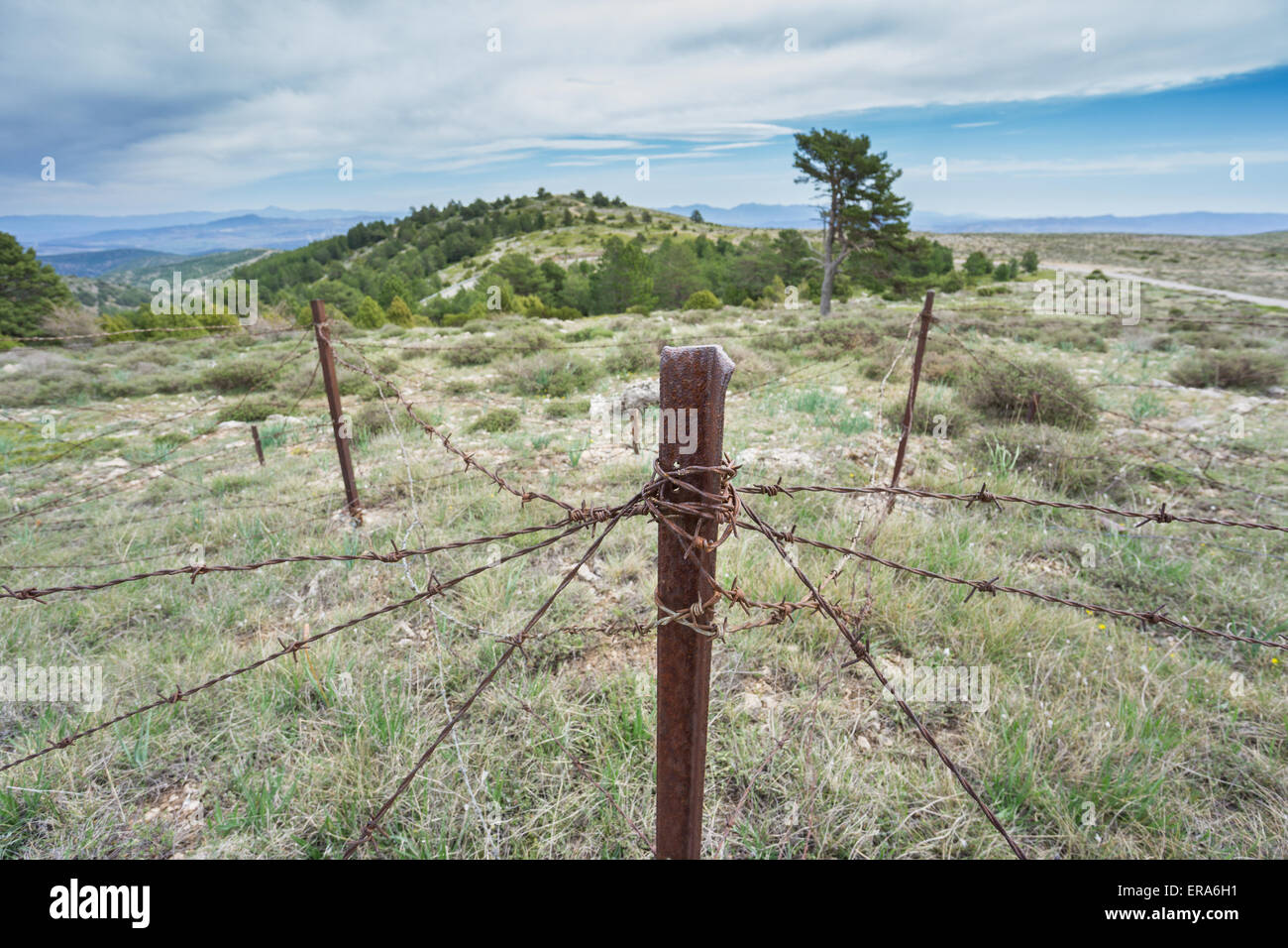 Zone militaire abandonné avec rusty spiked fence Banque D'Images
