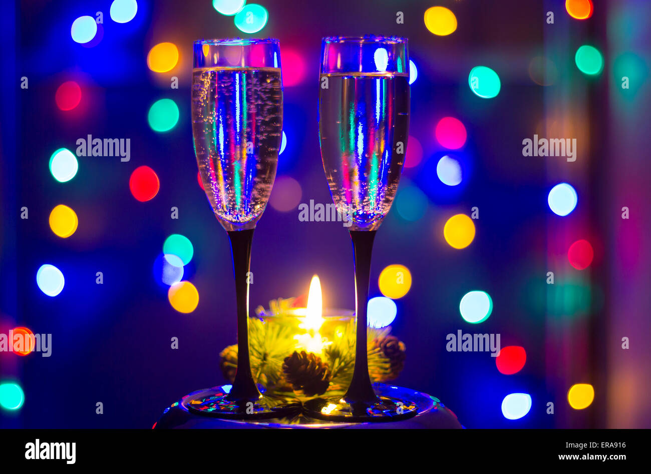 Verres de champagne et une bougie avec fond coloré Banque D'Images