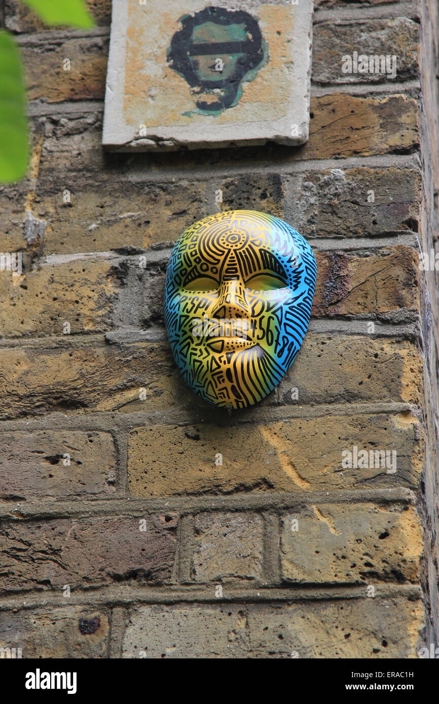 Masque de visage sur un mur à Brick Lane Banque D'Images
