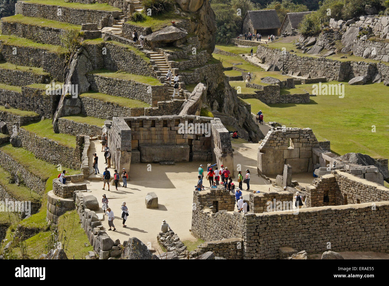 Les touristes explorant Plaza sacrée dans les ruines Inca de Machu Picchu, Pérou Banque D'Images