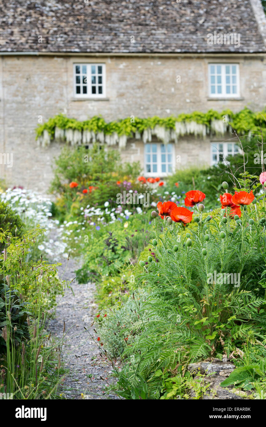 Jardin de fleurs et le chemin d'en face d'un chalet en Ablington. Cotswolds, Gloucestershire, Angleterre Banque D'Images