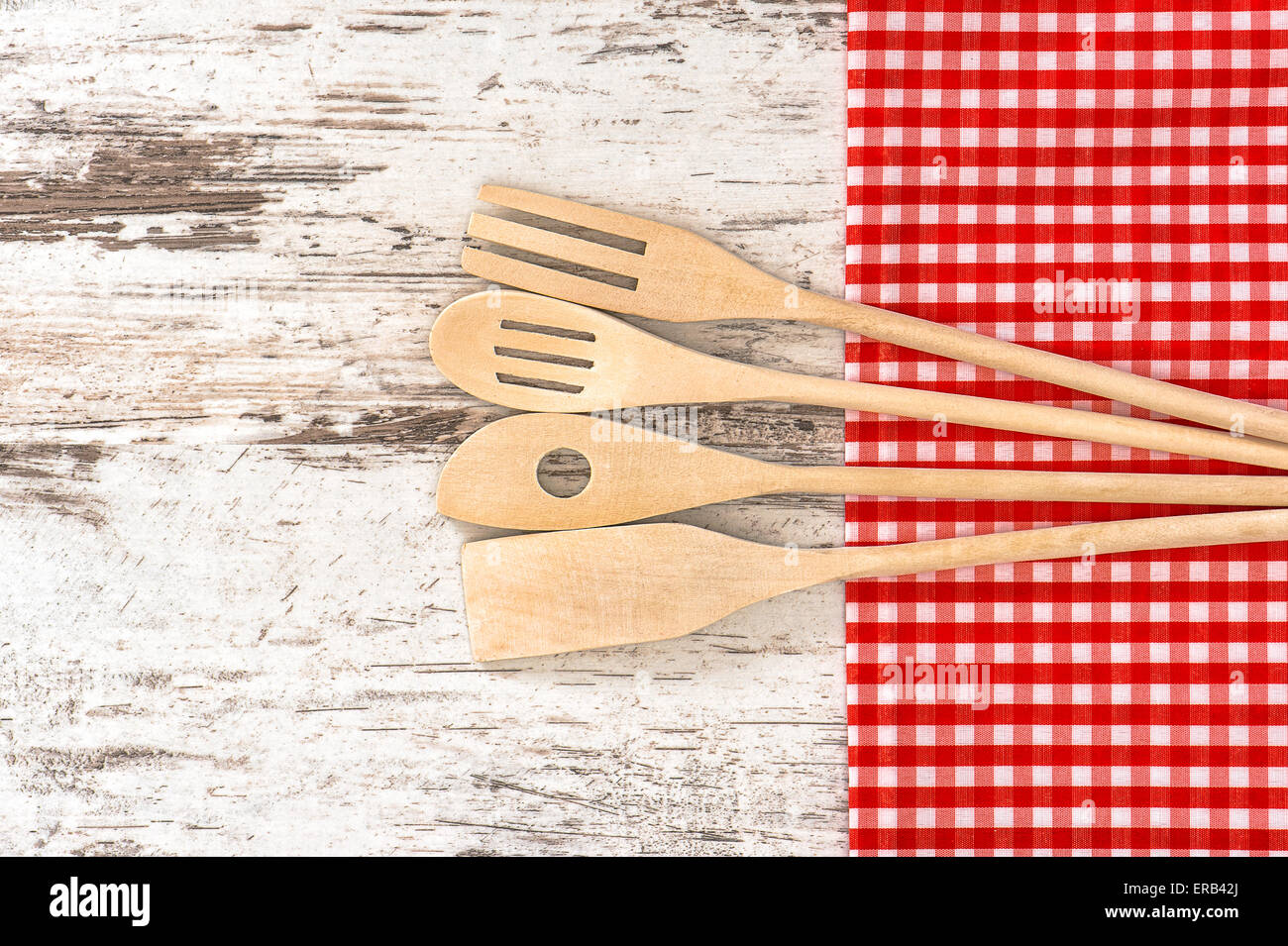 Des ustensiles de cuisine en bois et nappe rouge. Outils pour la préparation des aliments Banque D'Images