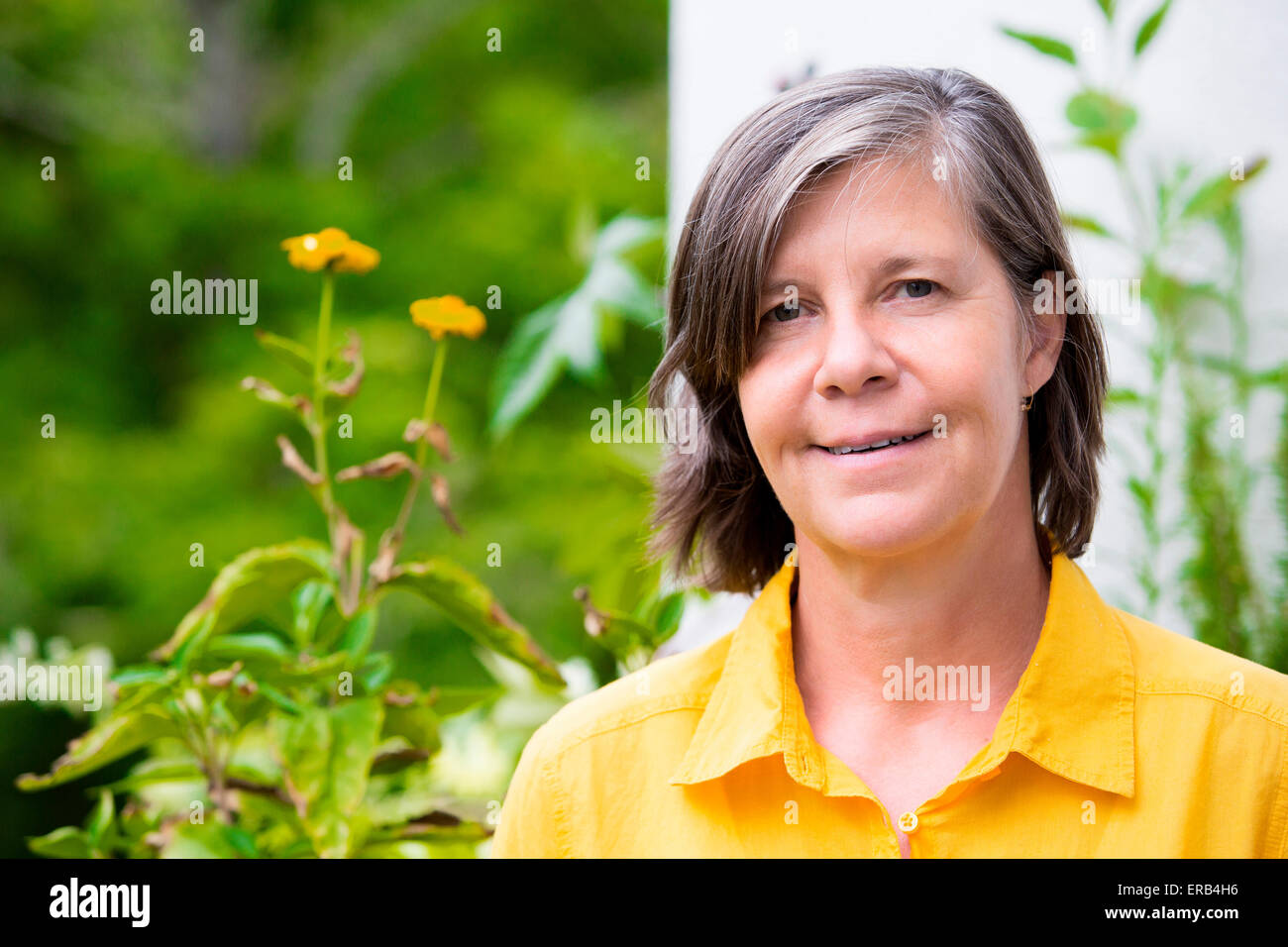 Portrait d'une femme plus âgée sur son balcon et smiling Banque D'Images