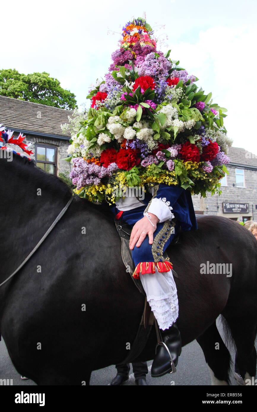 Portant une coiffe de fleurs, le processus grâce à Castleton Roi Garland dans le Peak District pour célébrer le Jour de la pomme de chêne UK Banque D'Images