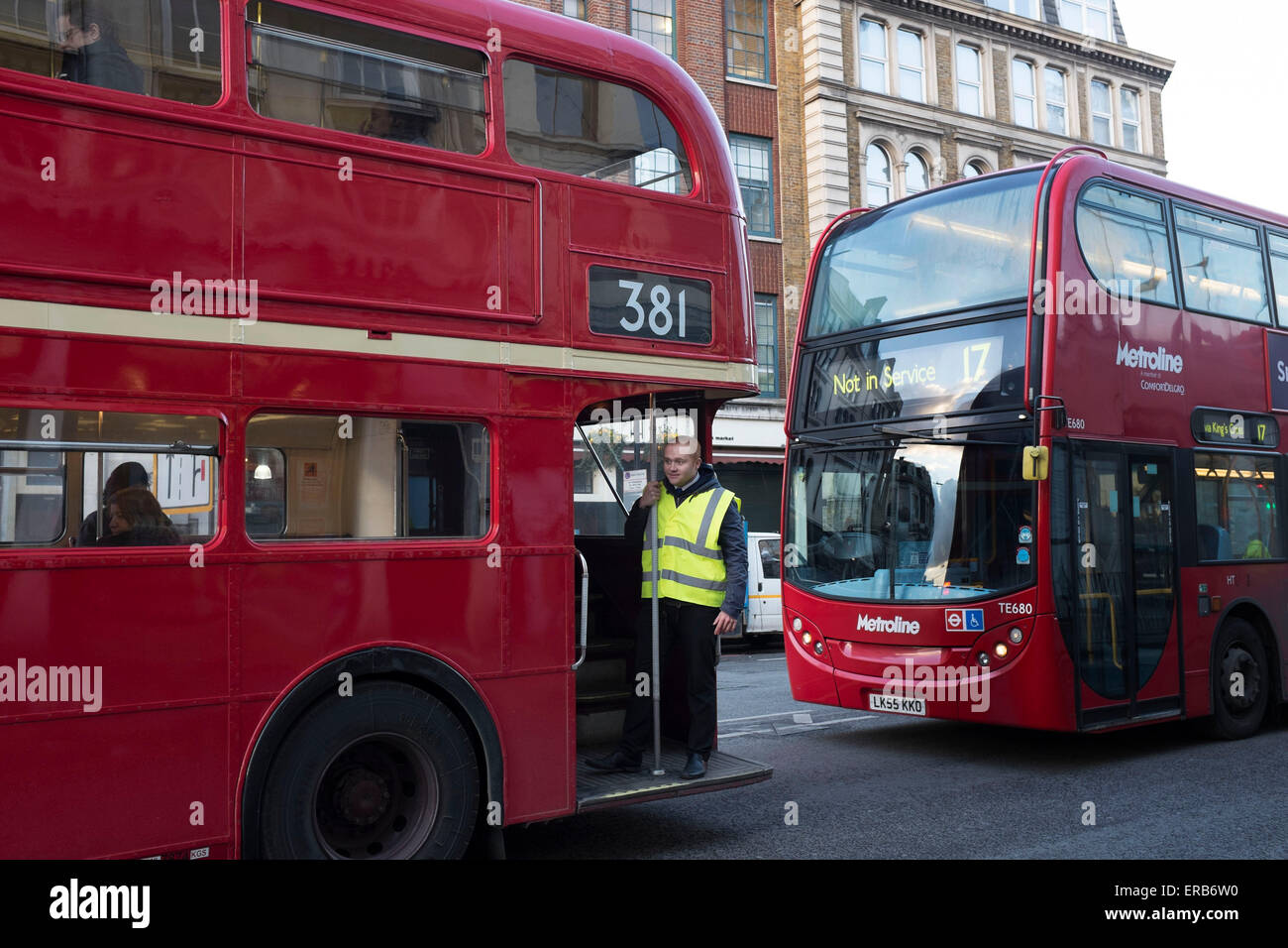 Conducteur de bus se trouve sur la plaque d'assise d'un vieux bus Routemaster rouge à Londres, pont, au Royaume-Uni. Cette façon de "hop on, hop off'. Banque D'Images