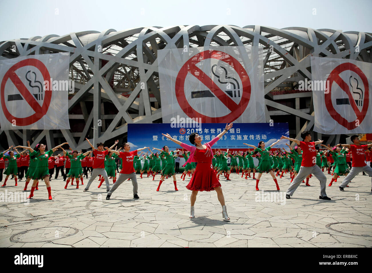 Beijing, Chine. 31 mai, 2015. Les interprètes dansent devant des bannières affichées sur le Nid d'oiseau emblématique du stade national de la Journée mondiale sans tabac, à Beijing, capitale de Chine, le 31 mai 2015. Beijing prévoit de présenter un nouveau règlement le 1 juin exigeant que tous les lieux publics intérieurs - et de nombreux lieux publics extérieurs - pour être 100 % sans fumée. Le projet de loi est considéré comme le plus rigoureux de la loi anti-tabac dans l'histoire de la Chine. © Shen Bohan/Xinhua/Alamy Live News Banque D'Images