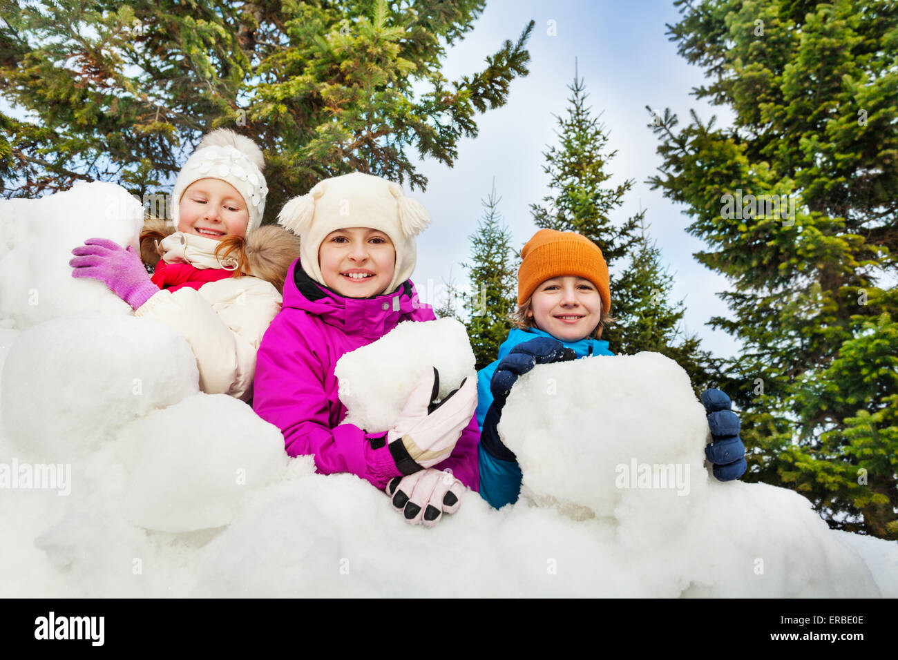 Vue rapprochée d'enfants heureux derrière le fort de neige Banque D'Images