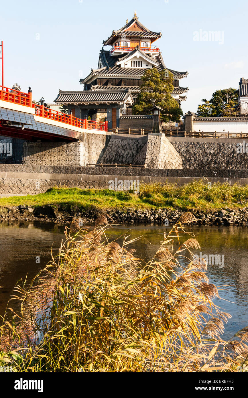 Château de Kiyosu à Nagoya, pendant l'heure d'or vue de l'autre côté de la rivière avec son pittoresque pont de vermillon menant à l'entrée du château. Banque D'Images