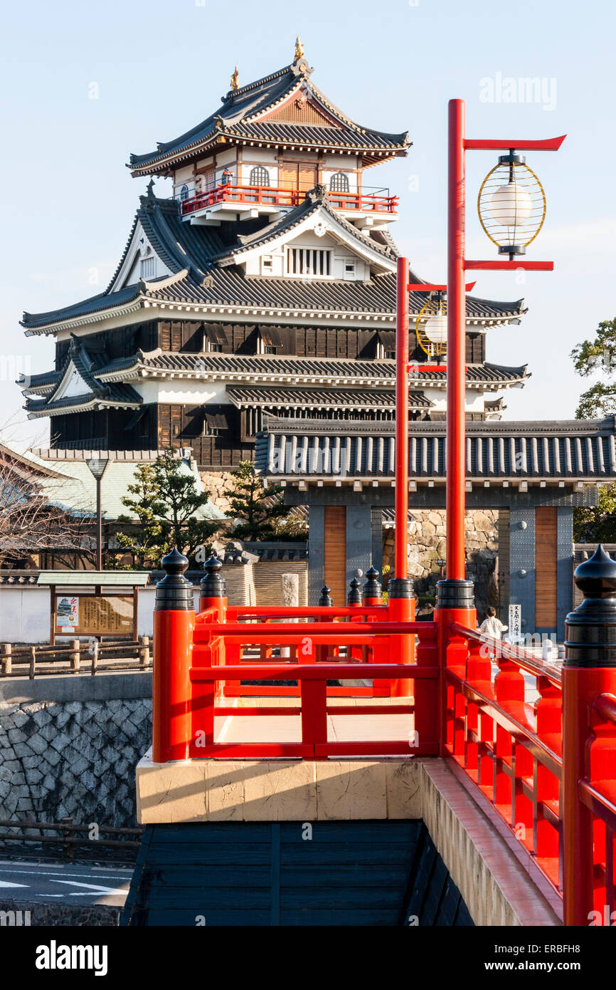 Japon, Nagoya. Reconstruction en béton d'un pont fluvial en bois avec des rampes et des lampes vermilion, menant au château de Kiyosu avec fond bleu ciel. Banque D'Images