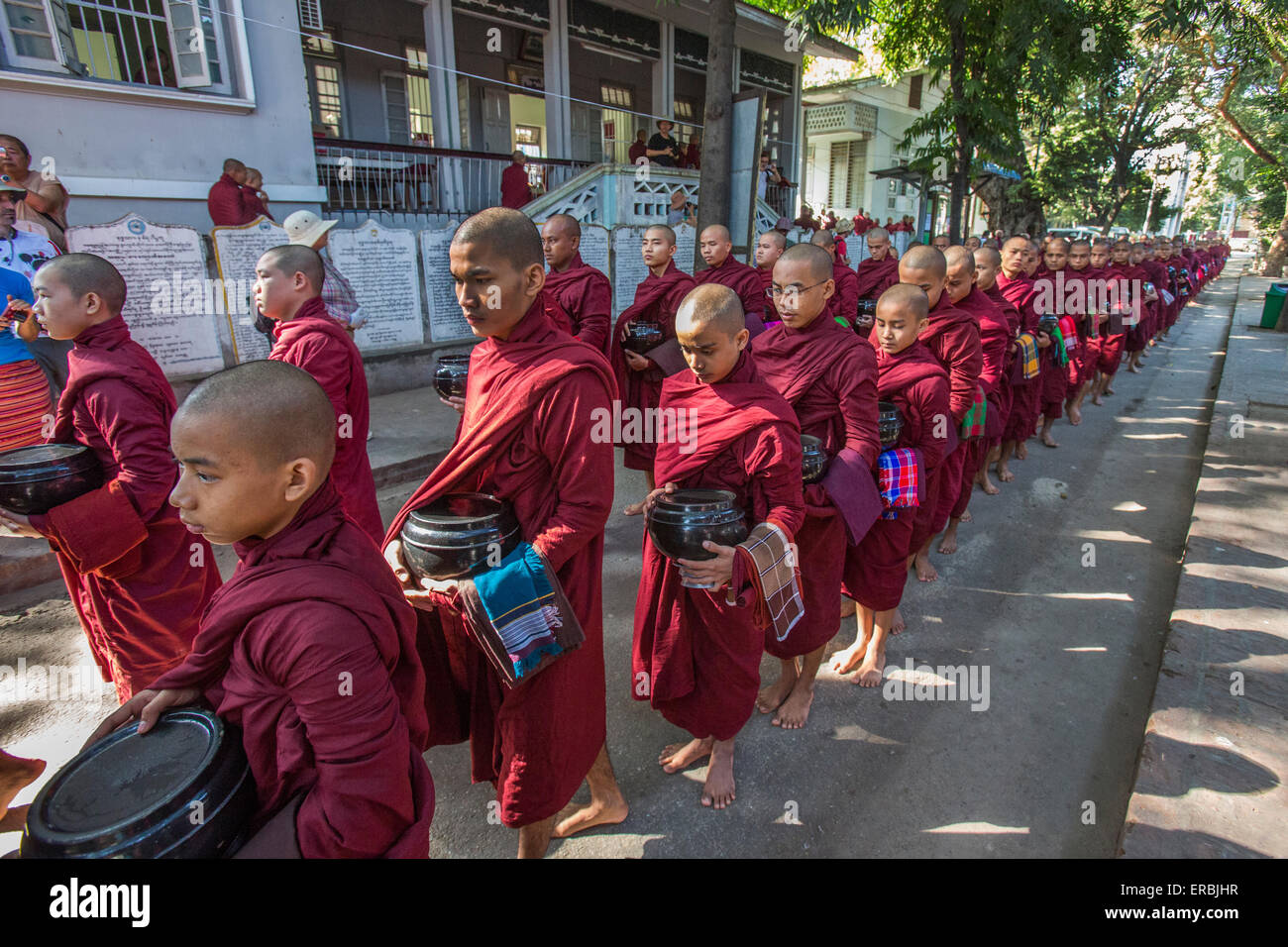 Moines alignés pour le dernier repas de la journée au monastère Amarapura, Mandalay Myanmar Banque D'Images
