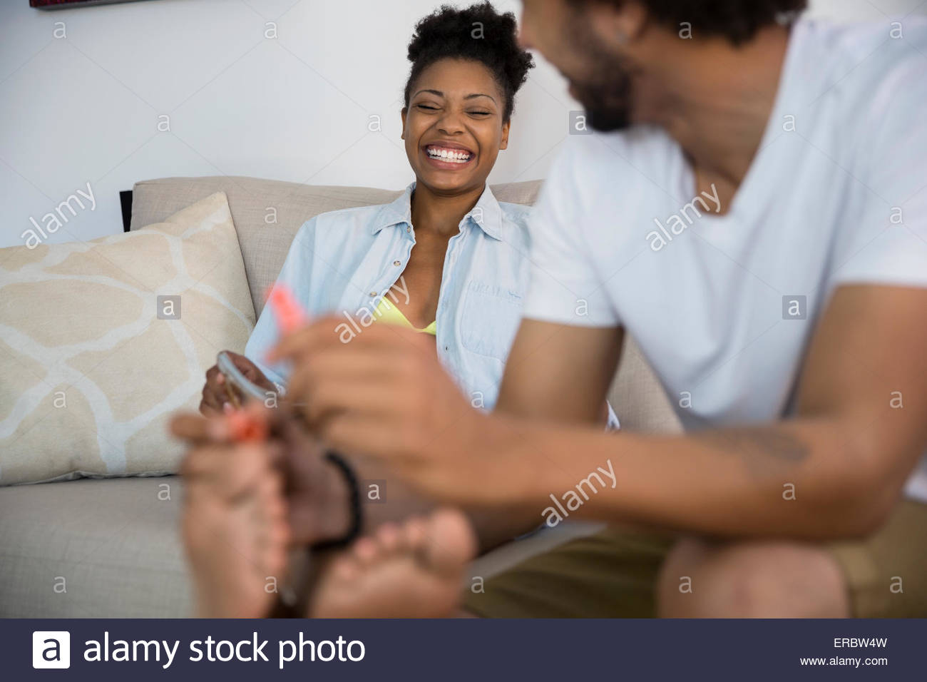 Man giving girlfriend pédicure Banque D'Images