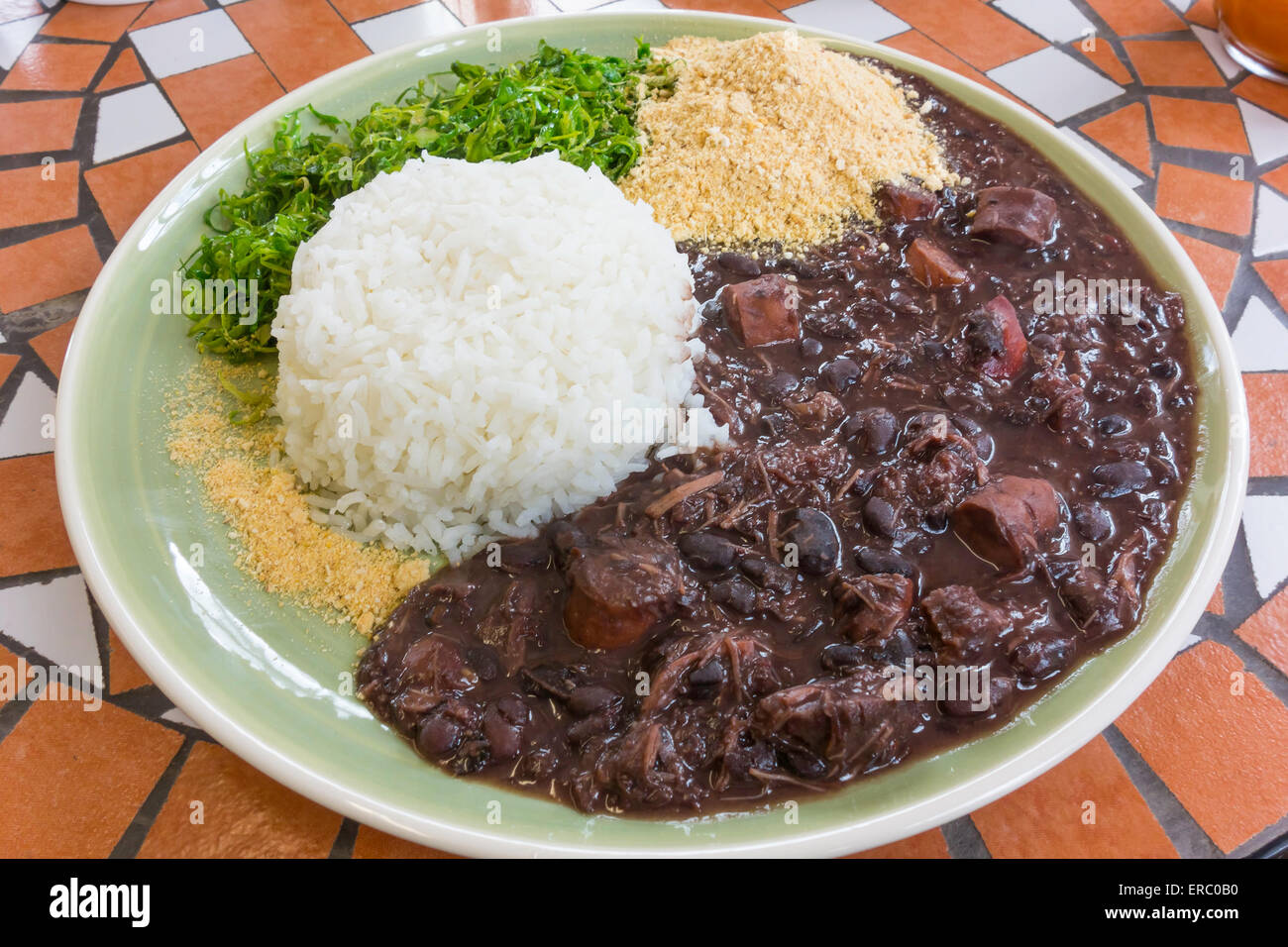 Café le déjeuner d'un plat de viande et de haricots noirs Feijoada ragoût avec de la farine de manioc et de riz chou râpé dans un restaurant Brésilien Banque D'Images