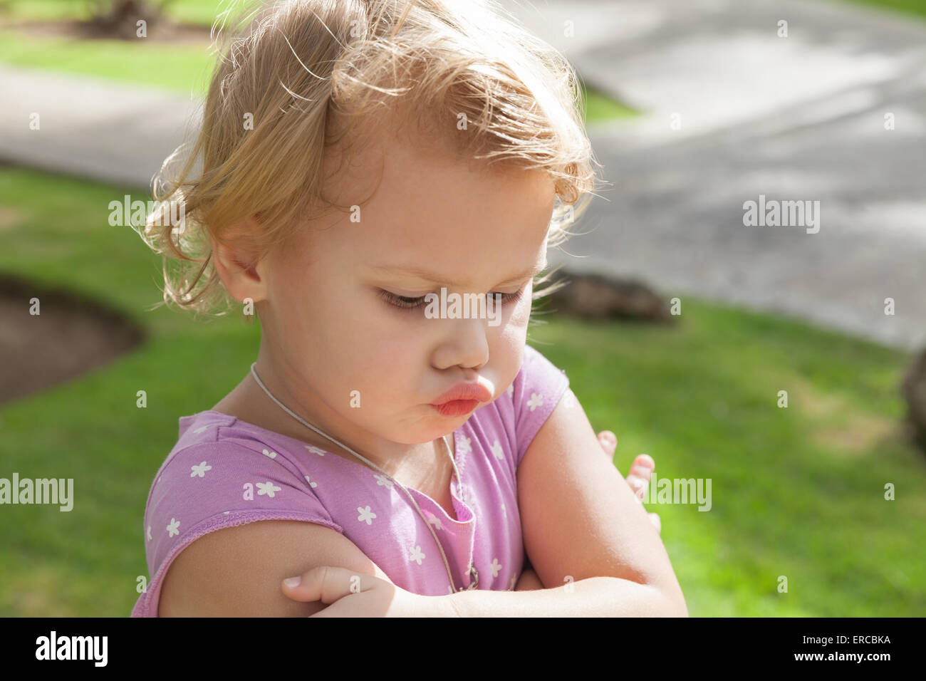 Closeup portrait en extérieur, funny Caucasian baby girl blonde resentfully moues Banque D'Images
