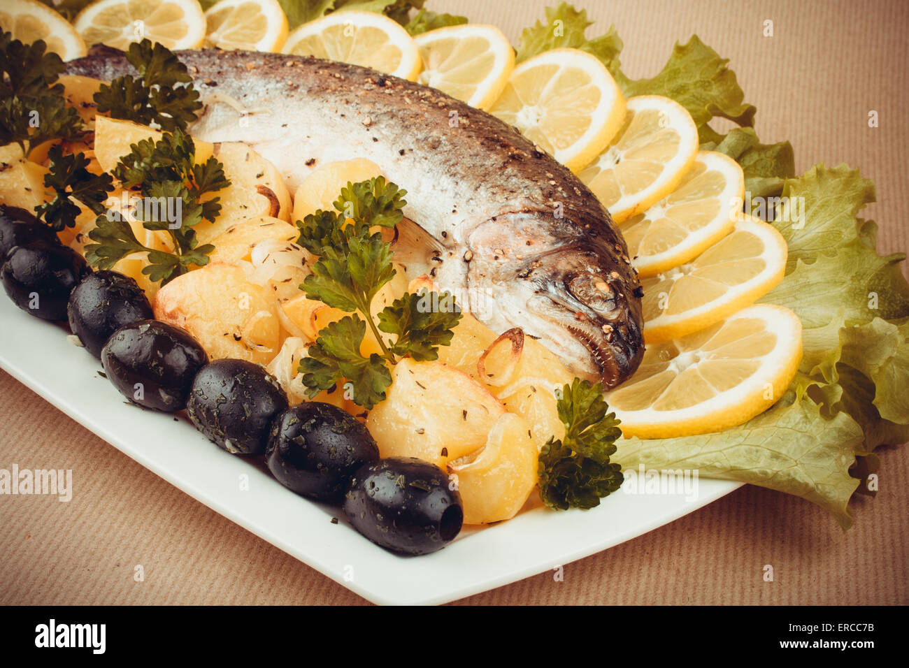 Truite grillée avec des légumes et pommes de terre, olive, tons rétro Banque D'Images
