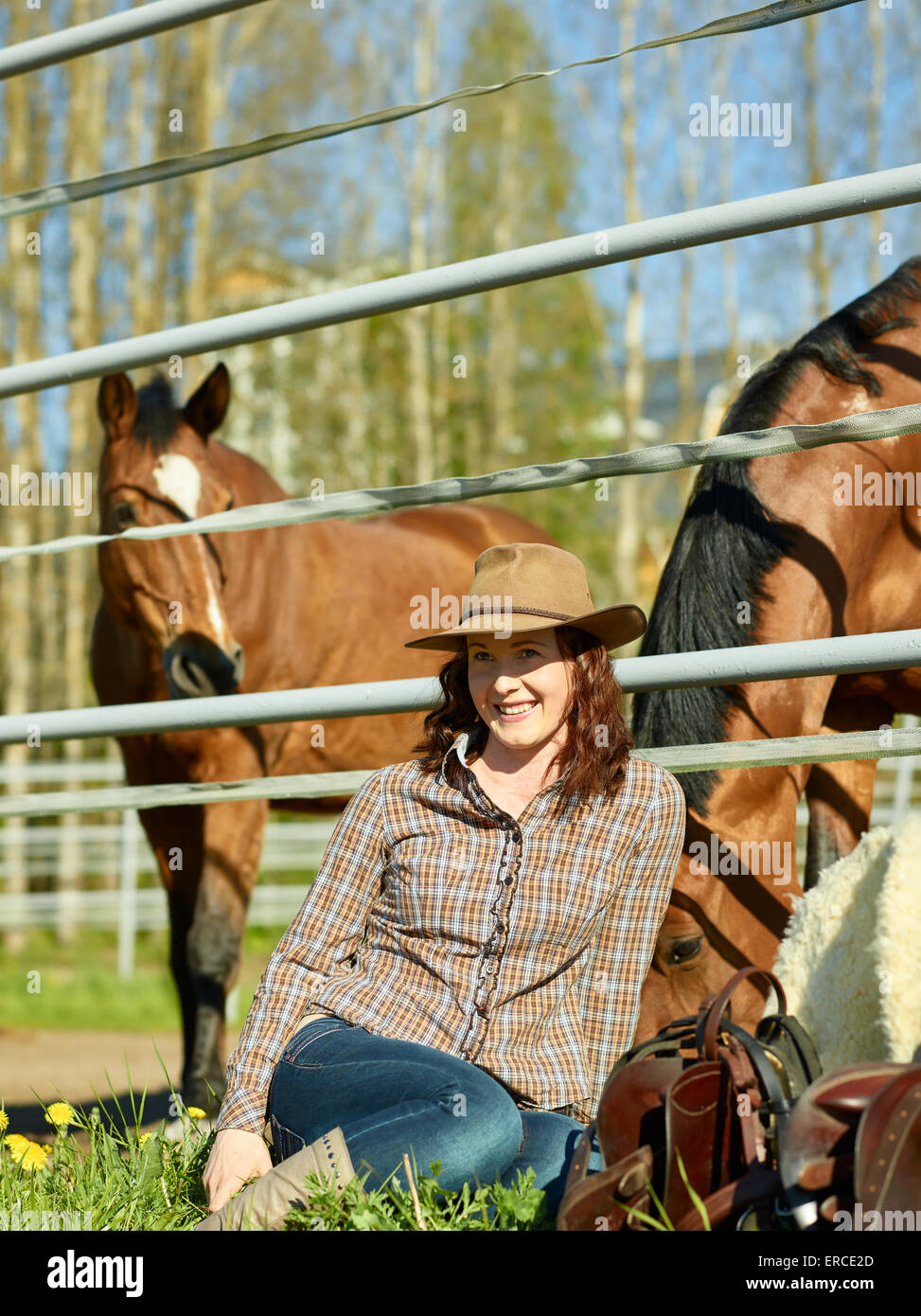 Cowgirl et selle, cheval dans un enclos Banque D'Images