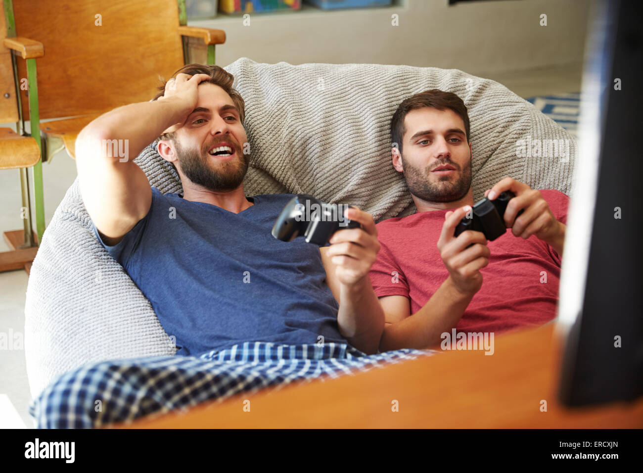 Deux amis en pyjama à l'ensemble de jeux vidéo Banque D'Images