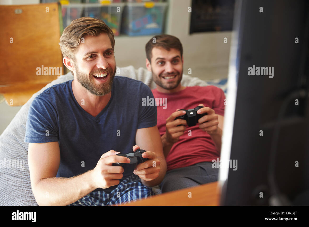 Deux amis en pyjama à l'ensemble de jeux vidéo Banque D'Images