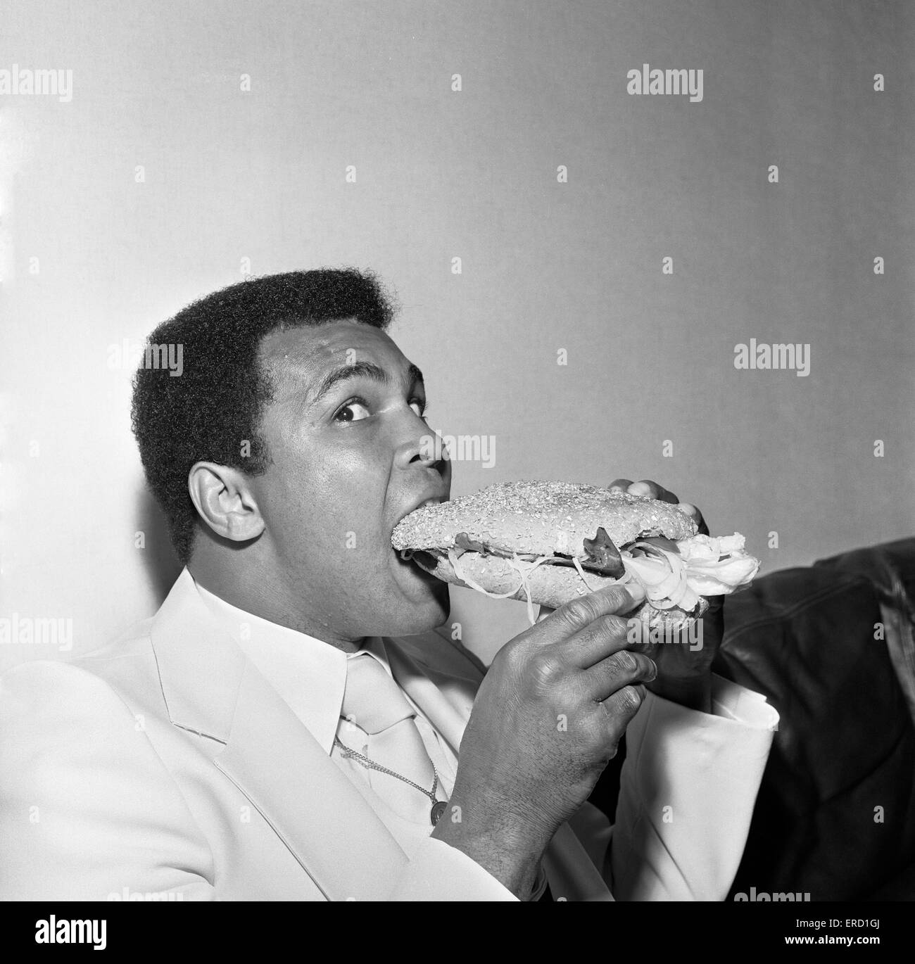 Muhammad Ali le Louisville Lip réduit au silence par un Stottie, Gâteau traditionnel d'une délicatesse Geordie farci de la laitue, l'oignon, le concombre et la tomate. Photo prise lors de sa tournée de Tyneside, Newcastle. 16 Juillet 1977 Banque D'Images