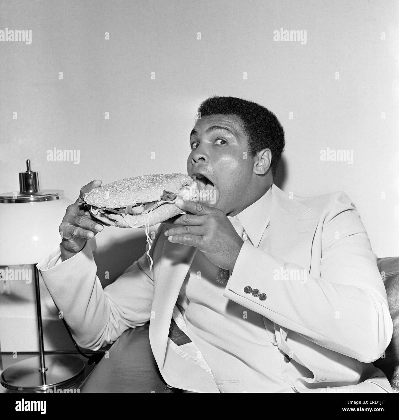 Muhammad Ali le Louisville Lip réduit au silence par un Stottie, Gâteau traditionnel d'une délicatesse Geordie farci de la laitue, l'oignon, le concombre et la tomate. Photo prise lors de sa tournée de Tyneside, Newcastle. 16 Juillet 1977 Banque D'Images