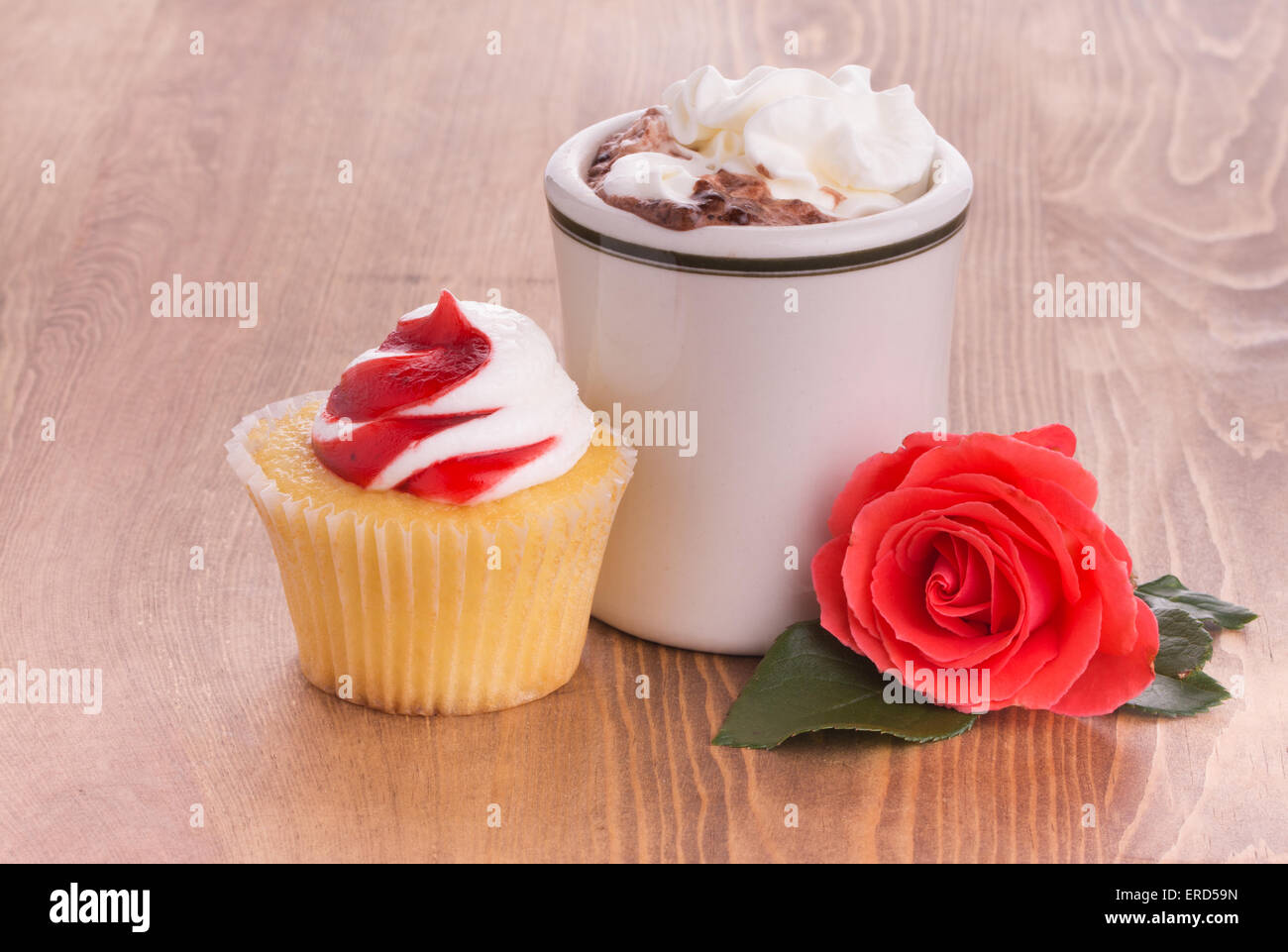 Cupcake fraise avec une tasse de chocolat chaud et un brillant rose rouge sur la table en bois sombre - anniversaire ou traiter la Saint-Valentin Banque D'Images