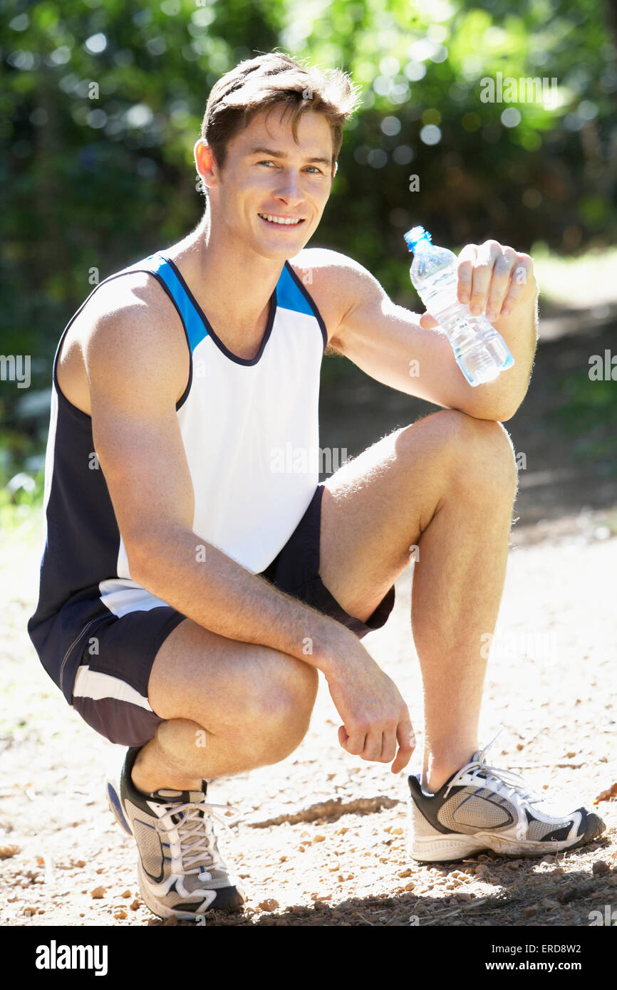 Bouteilles d'eau potable l'homme tandis que le jogging Banque D'Images