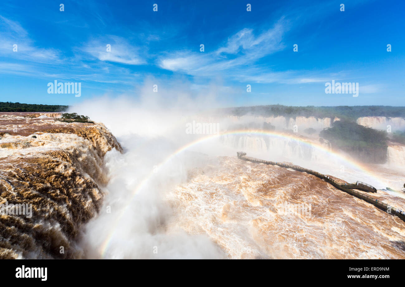 D'Iguazu, prises depuis le côté brésilien, en arc-en-ciel au-dessus de la pulvérisation de la Gorge du Diable pont pont d'observation aux beaux jours Banque D'Images