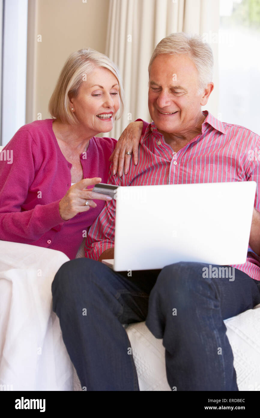 Couple Using Laptop pour achat en ligne à la maison Banque D'Images Couple Using Laptop pour achat en ligne à la maison Banque D'Images
