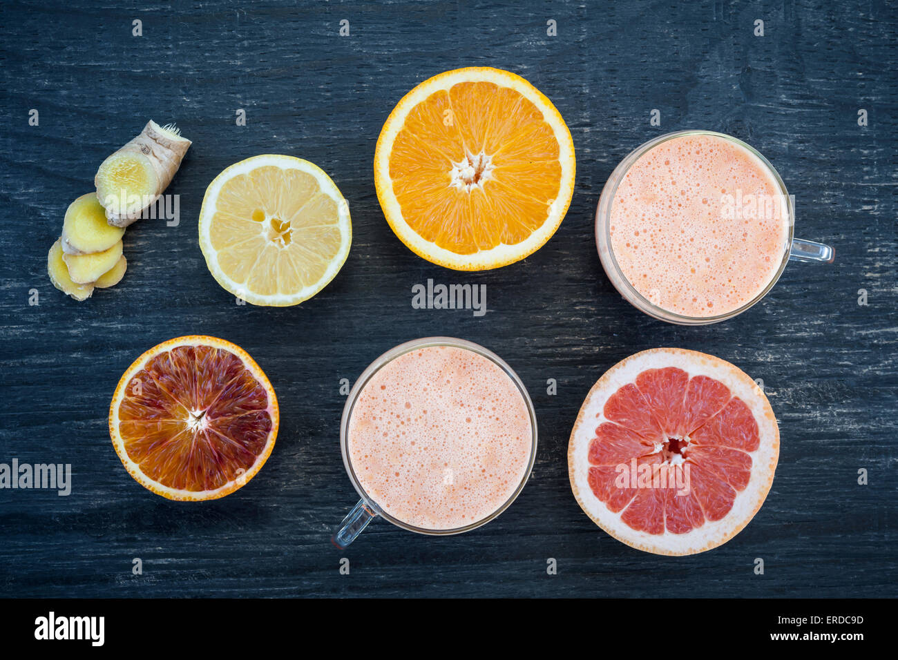 Les agrumes frais et le gingembre smoothies avec tranches de fruits sur fond de bois rustique, vue d'en haut Banque D'Images