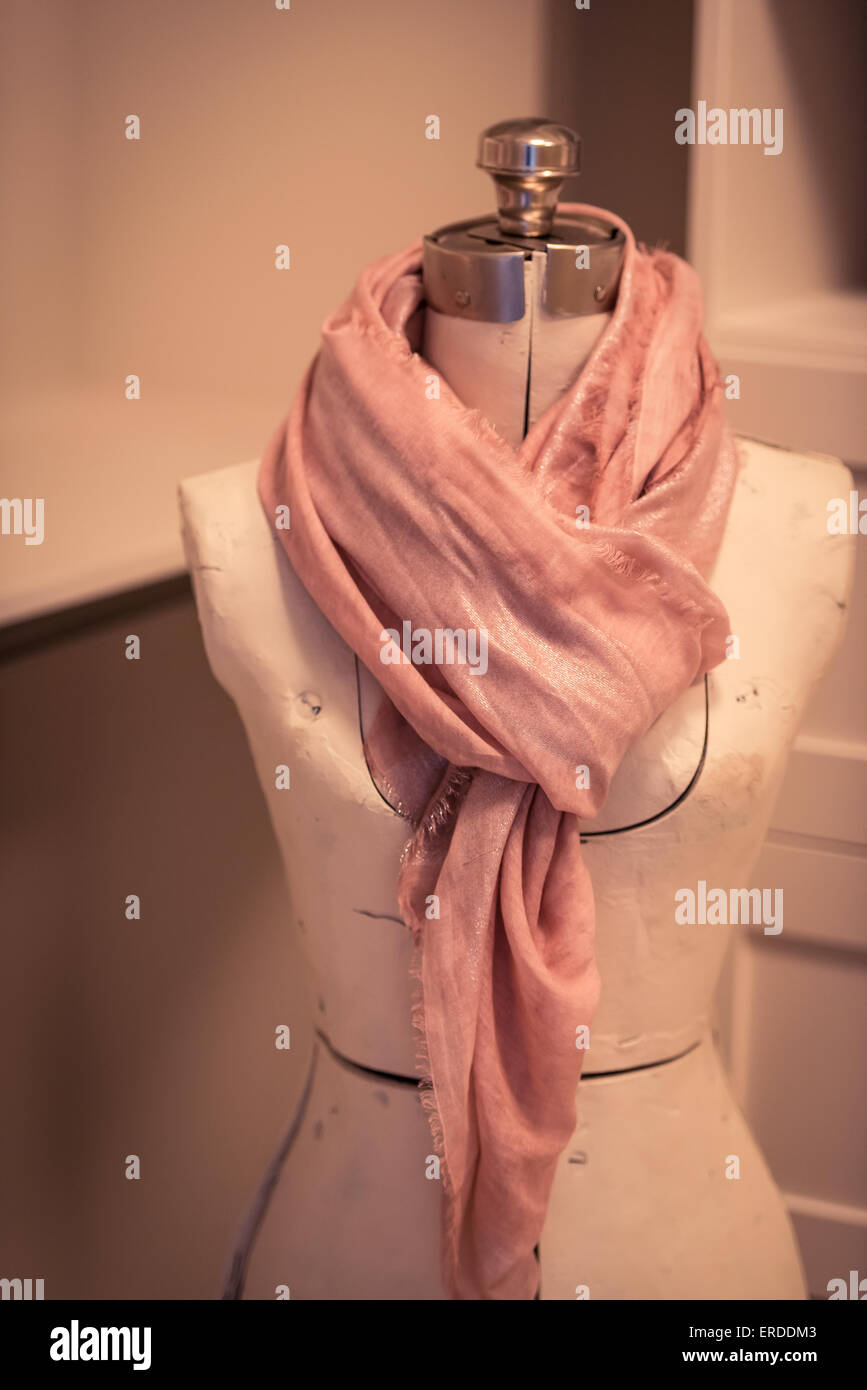 Une écharpe rose enroulée autour d'un mannequin de designer de vêtements. Banque D'Images