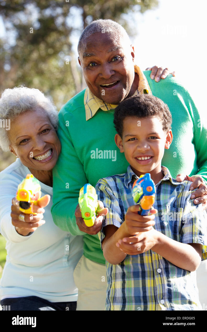 Les grands-parents et petit-fils tir pistolets à eau Banque D'Images