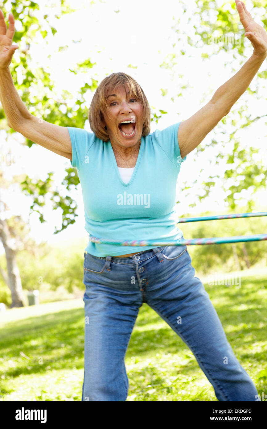 Senior Hispanic Woman with Hula Hoop In Park Banque D'Images