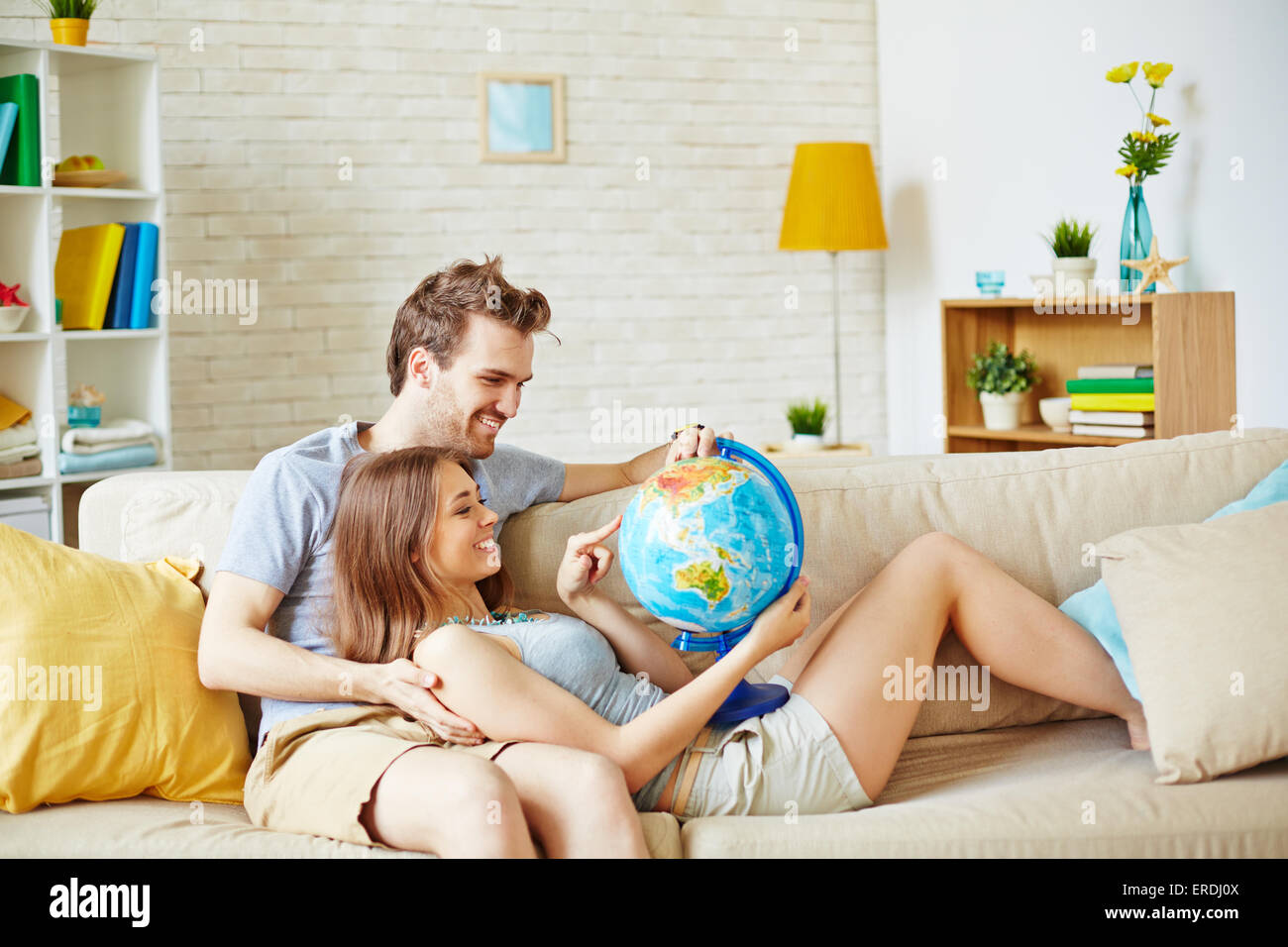Couple heureux avec globe choisir place pour l'été reste Banque D'Images