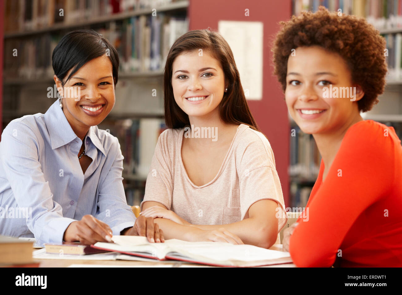 2 Les étudiants qui travaillent dans la bibliothèque avec l'enseignant Banque D'Images